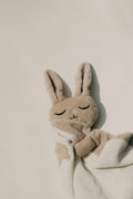 Soft cream linen plush bunny resting on a small cloth
