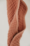 Soft double gauze muslin swaddle in warm rust colour
