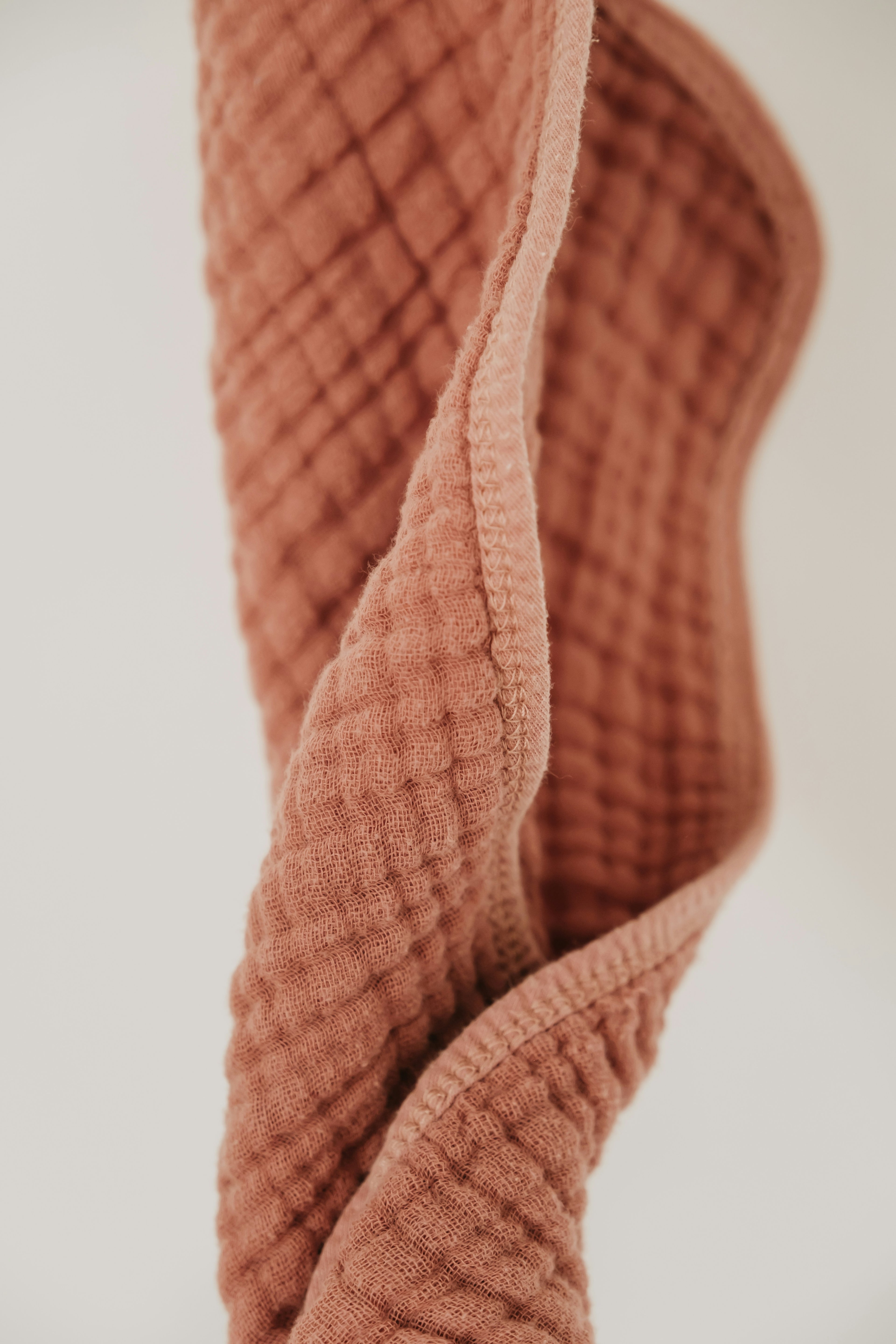 Soft double gauze muslin swaddle in warm rust colour