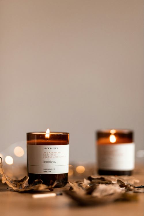 Pair of amber glass candles with warm bokeh light behind