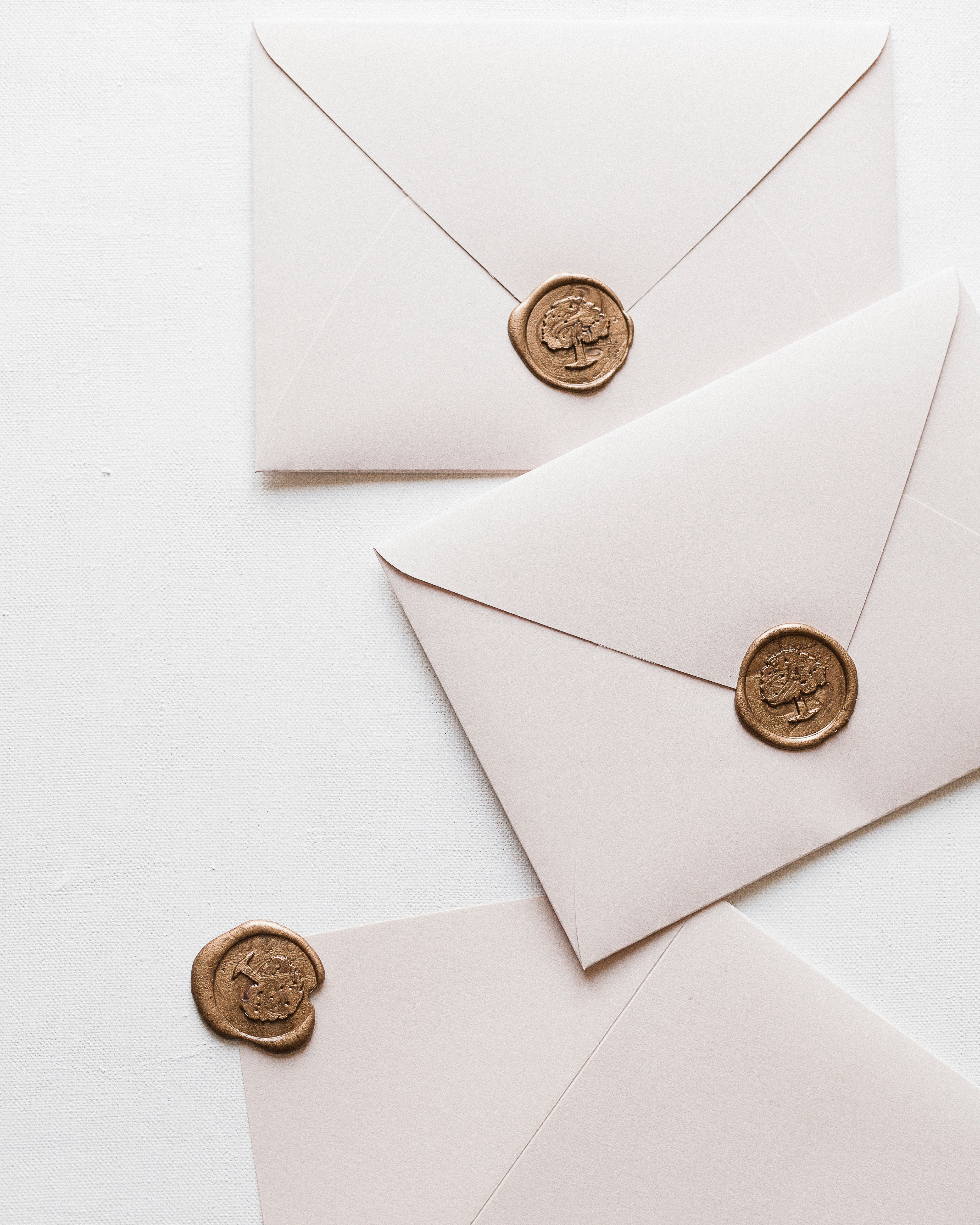 Wax-sealed cream envelopes on a paper surface