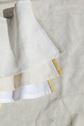 Folded linen napkins with subtle ribbon detail on the hem