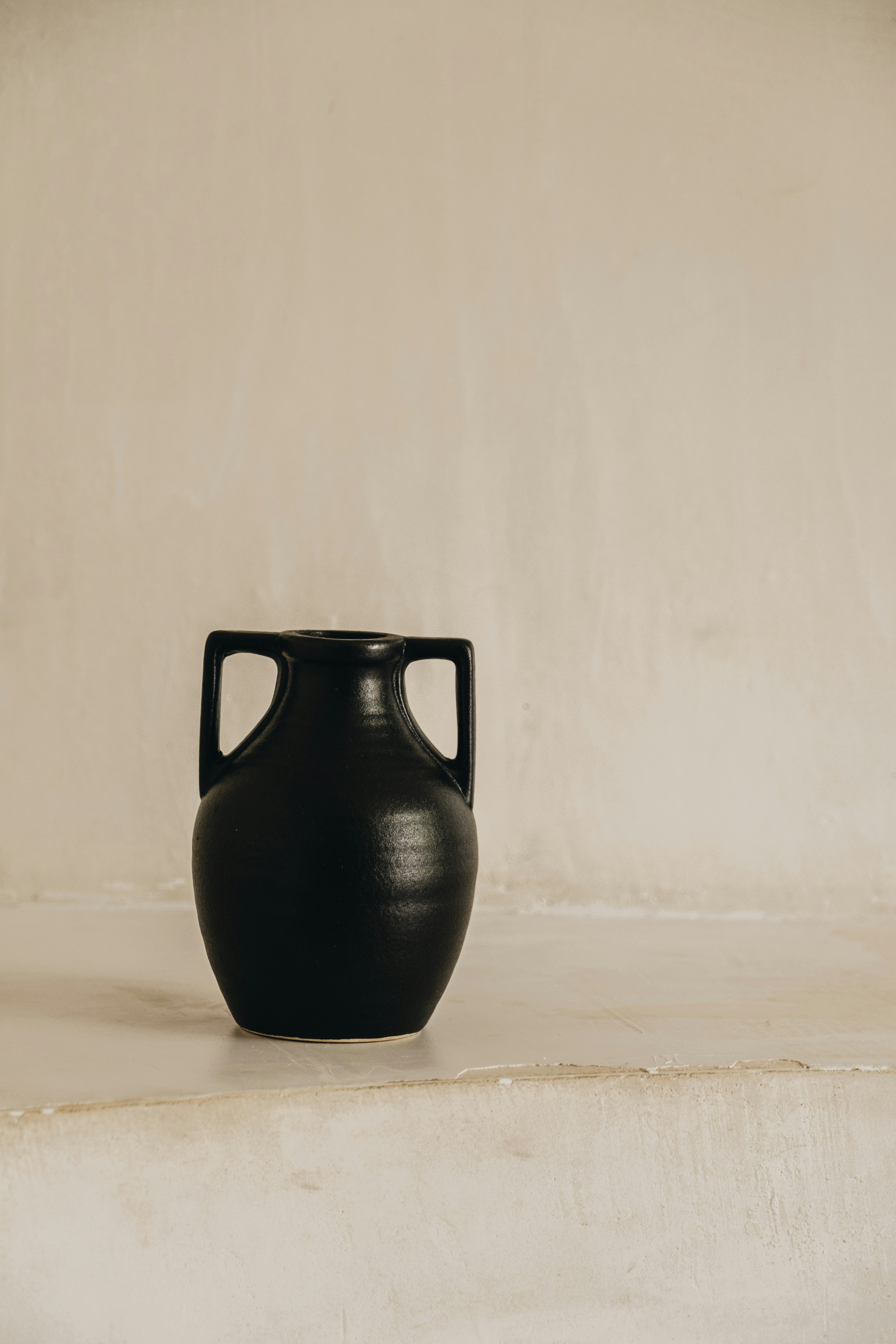Small matte black amphora vase with two handles