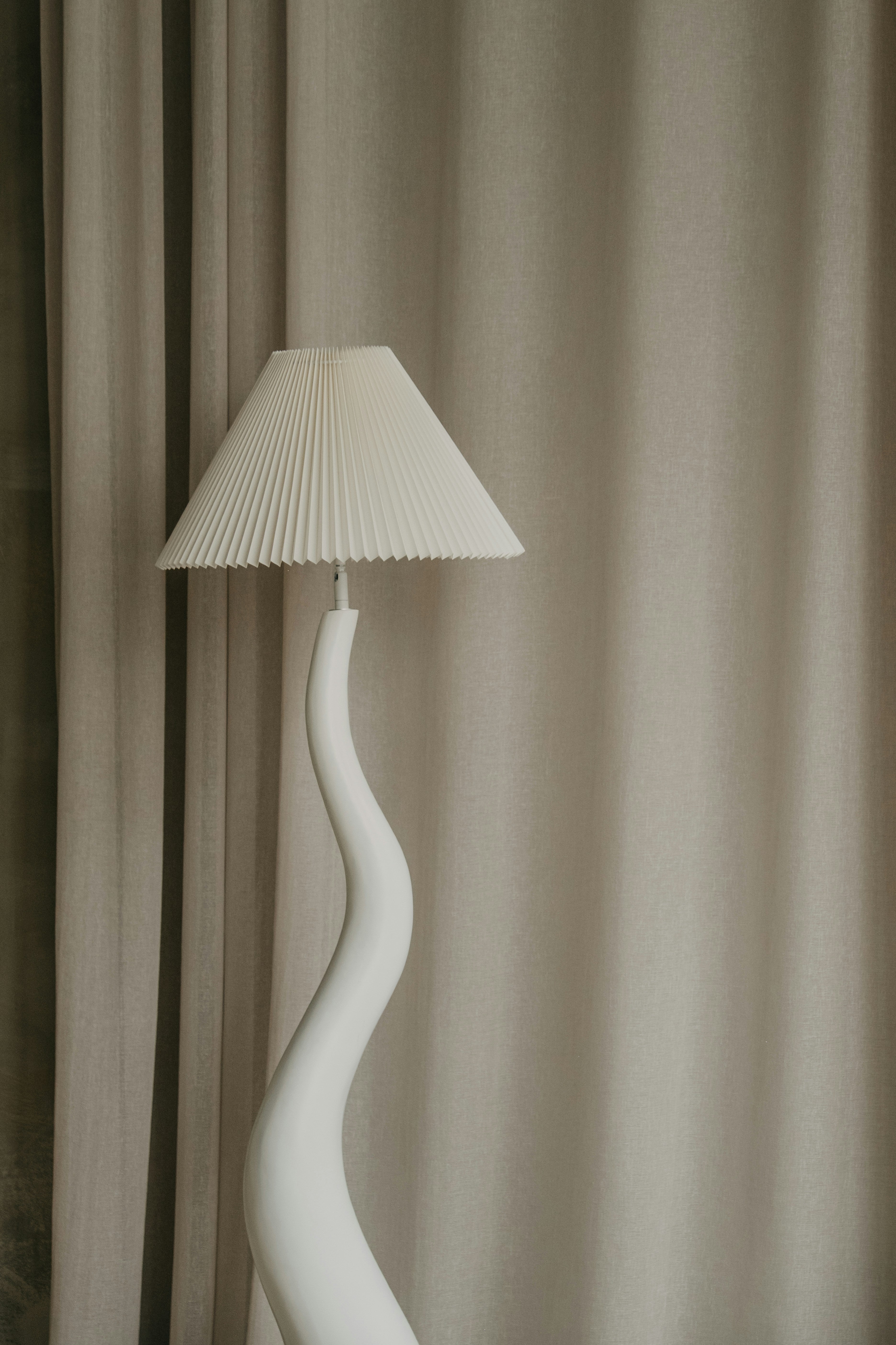 Pleated linen lampshade on sculptural ceramic base