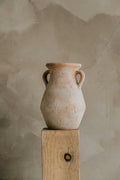 Hand-finished terracotta amphora vase on a wooden pedestal