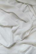 Soft white stonewashed linen bed sheet, crumpled and natural