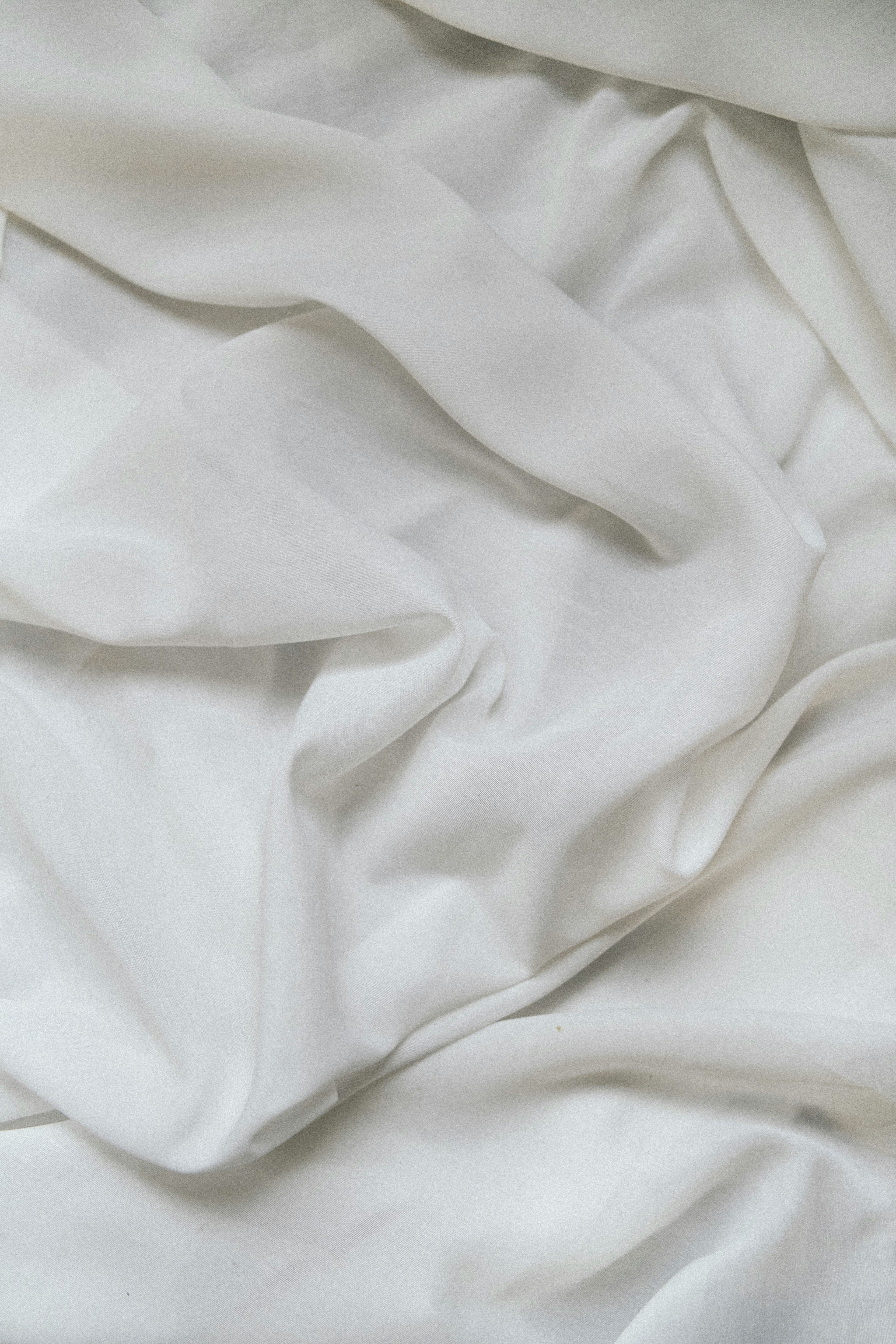 Soft white stonewashed linen bed sheet, crumpled and natural