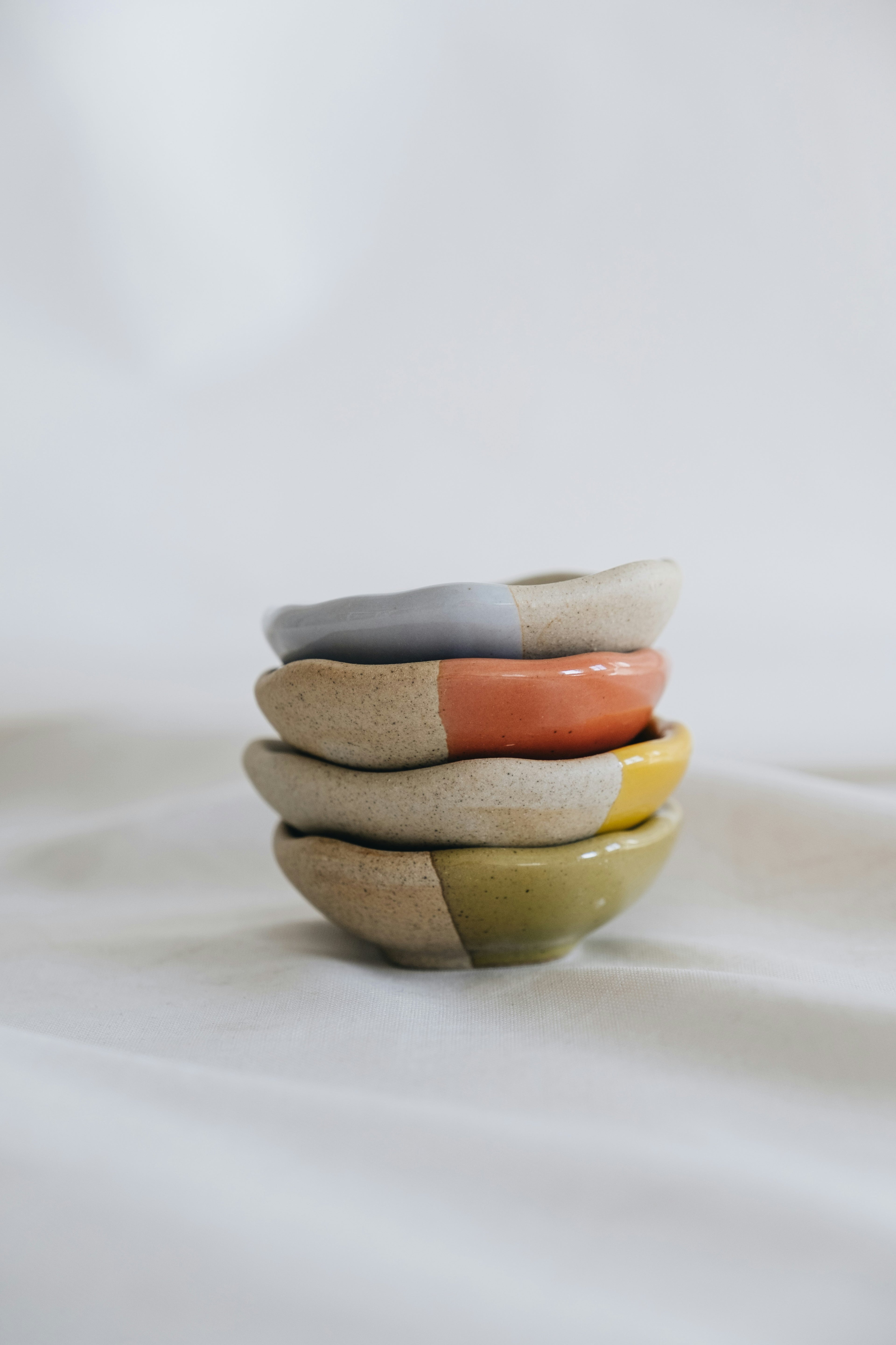 Hand-thrown stoneware bowls stacked, oat and sage glaze