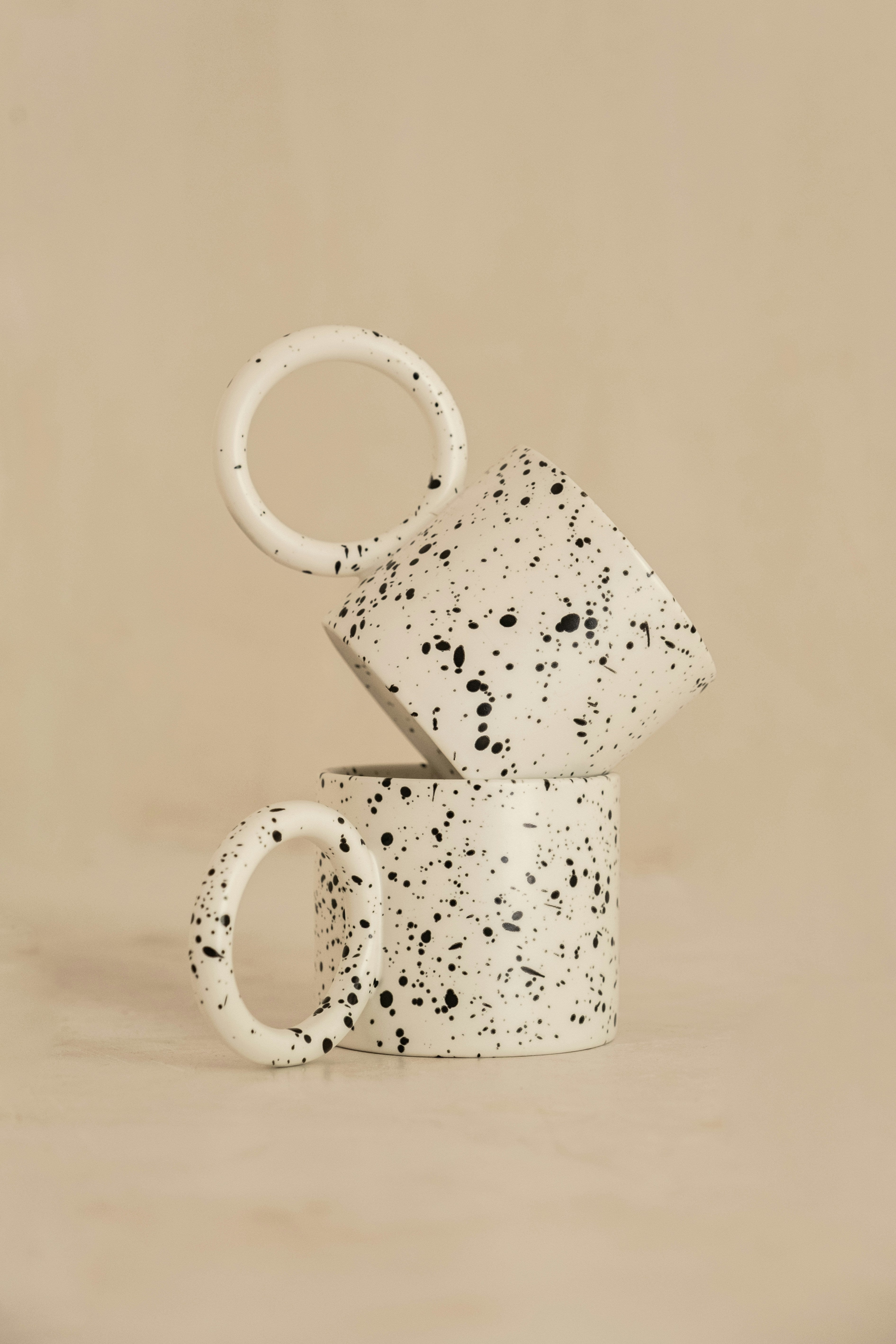 Pair of cream stoneware mugs with black speckled glaze